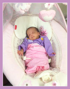 Photo of a small child asleep in a cot.