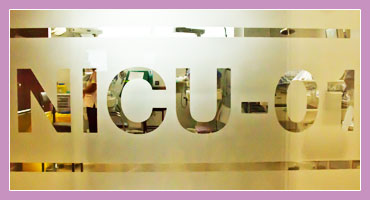 Close up photo of door into NICU at Holles Street Hospital. Transluscent glass features text 'NICU-01'