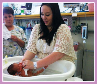 Photo of mother bathing her premature child.